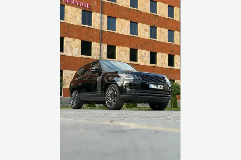 Чёрный Range Rover Vogue у кирпичного здания